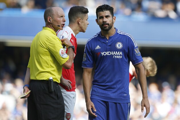 Referee Michael Dean holds a yellow cards after booking both Chelsea's Diego Costa, right, and Arsenal's Gabriel during the English Premier League soccer match between Chelsea and Arsenal at Stamford Bridge stadium in London, Saturday, Sept. 19 2015. Arsenal's Gabriel was sent off moments later for a further clash with Costa .(AP Photo/Alastair Grant)