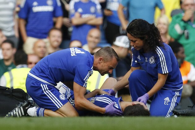 Chelsea doctor (R) Eva Carneiro and head physio Jon Fearn (L) treat Chelsea's Belgian midfielder Eden Hazard late on during the English Premier League football match between Chelsea and Swansea City  at Stamford Bridge in London on August 8, 2015. Chelsea have sidelined team doctor Eva Carneiro from match-day duties after she fell foul of manager Jose Mourinho, according to British media reports on August 11, 2015. Mourinho criticised Carneiro after she ran on the pitch to treat Eden Hazard in stoppage time of Chelsea's 2-2 draw at home to Swansea City on August 8, saying she did not 'understand the game'. AFP PHOTO / IAN KINGTON

RESTRICTED TO EDITORIAL USE. No use with unauthorized audio, video, data, fixture lists, club/league logos or 'live' services. Online in-match use limited to 75 images, no video emulation. No use in betting, games or single club/league/player publications.        (Photo credit should read IAN KINGTON/AFP/Getty Images)