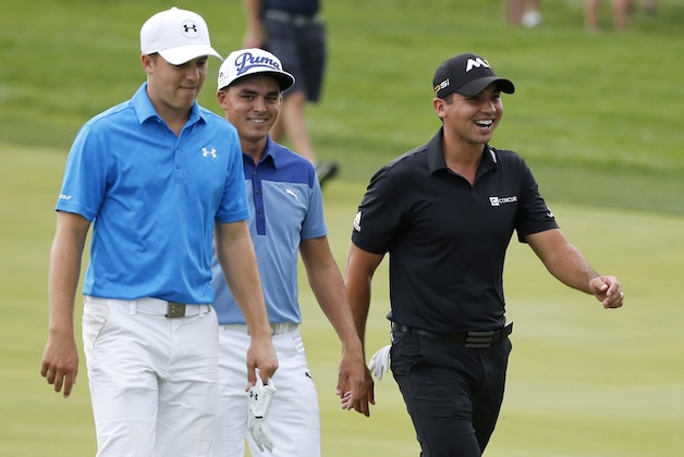 Jordan Spieth, left, Rickie Fowler, center and Jason Day of Australia, walk to mark their balls on the ninth fairway after play was suspended for severe weather during the first round of the BMW Championship golf tournament at Conway Farms Golf Club, Thursday, Sept. 17, 2015, in Lake Forest, Ill. (AP Photo/Charles Rex Arbogast)