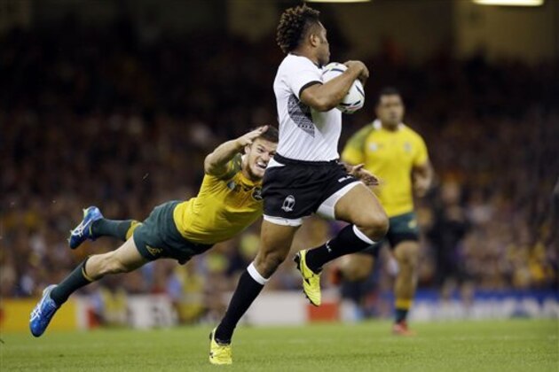 Australia's Rob Horne dives to tackle Fiji's Nikola Matawalu during the Rugby World Cup Pool A match between Australia and Fiji at the Millennium Stadium, Cardiff,  Wednesday, Sept. 23, 2015. (AP Photo/Matt Dunham)