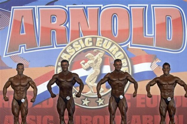 Competitors flex their muscles during the semifinal of the Arnold Classic Europe bodybuilding event in Madrid, Spain, Saturday, Oct. 13, 2012. (AP Photo/Andres Kudacki)