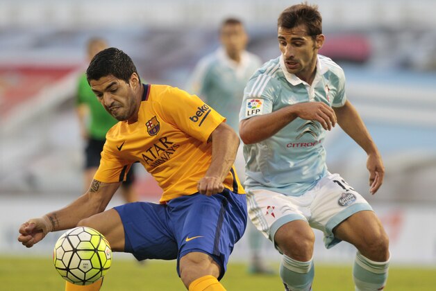 Barcelona's Luis Suarez from Uruguay, left, fights for the ball with RC Celta’s Jonny Castro, right, during a Spanish La Liga soccer match between RC Celta and FC Barcelona, at the Balaidos stadium in Vigo, Spain, Wednesday, Sept. 23, 2015. (AP Photo/Lalo R. Villar)