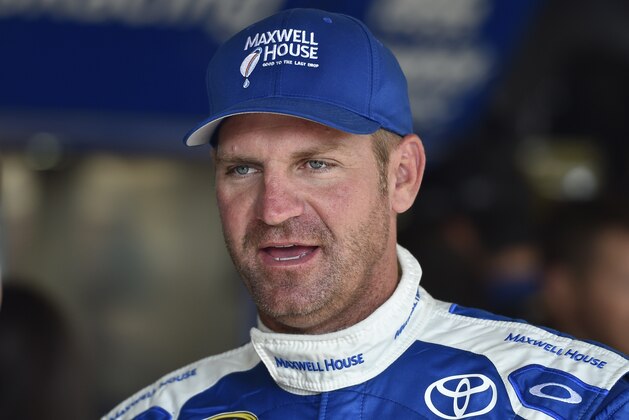Clint Bowyer stands in the garage area during practice for Sunday's NASCAR Sprint Cup series auto race at Watkins Glen International, Friday, Aug. 7, 2015, in Watkins Glen. N.Y. (AP Photo/Derik Hamilton)