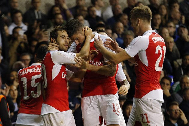 Arsenal's Mathieu Flamini, left,  celebrates with teammates after scoring during the English League Cup third round soccer match between Tottenham Hotspurs and Arsenal at White Hart Lane stadium in London, Wednesday, Sept. 23, 2015. (AP Photo/Frank Augstein)