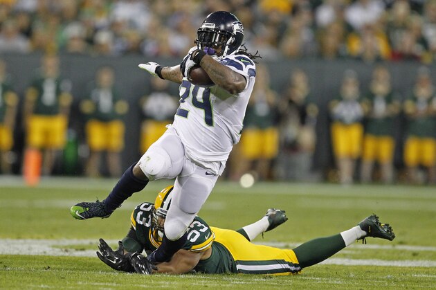 Seattle Seahawks running back Marshawn Lynch is tripped up by Green Bay Packers outside linebacker Nick Perry during an NFL football game Sunday Sept. 20, 2015, in Green Bay, Wis. (AP Photo/Matt Ludtke)