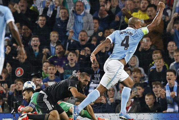 Manchester City's Vincent Kompany, right, celebrates after his header hit Juventus' Giorgio Chiellini, centre, for an own goal during the Champions League group D soccer match between Manchester City and Juventus at the Etihad Stadium, Manchester, England, Tuesday, Sept. 15, 2015. (AP Photo/Jon Super)