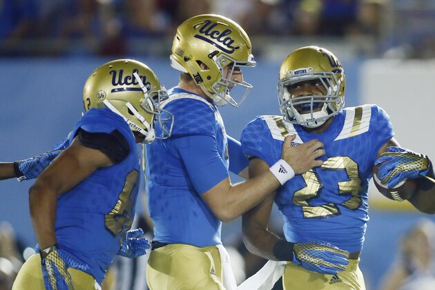 UCLA running back Nate Starks, right, celebrates scoring a touchdown with UCLA quarterback Josh Rosen, center, and wide receiver Eldridge Massington, left, against BYU late in the fourth quarter of an NCAA college football game, Saturday, Sept. 19, 2015, in Pasadena, Calif. UCLA won 24-23. (AP Photo/Danny Moloshok)