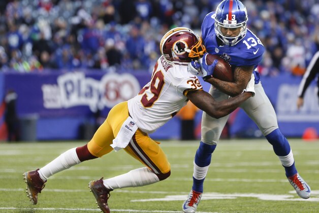 New York Giants wide receiver Odell Beckham (13) is tackled by Washington Redskins running back Roy Helu (29) during the third quarter of an NFL football game, Sunday, Dec. 14, 2014, in East Rutherford, N.J. (AP Photo/Julio Cortez)