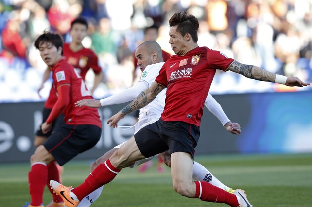 Atletico Mineiro's Diego Tardelli, center, kicks to score a goal past Guangzhou Evergrande's Zhang Linpeng, right, during the third place soccer match between Guangzhou Evergrande and Atletico Mineiro at the Club World Cup soccer tournament in Marrakech, Morocco, Saturday, Dec. 21, 2013. (AP Photo/Christophe Ena)