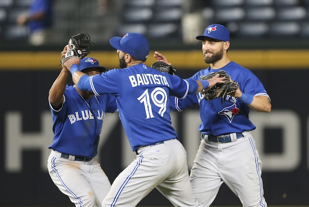 Toronto Blue Jays outfielders, from left, Ben Revere, Jose Bautista and Kevin Pillar celebrate after the Blue Jays defeated the Atlanta Braves 5-0 in a baseball game Thursday, Sept. 17, 2015, in Atlanta. (AP Photo/John Bazemore)