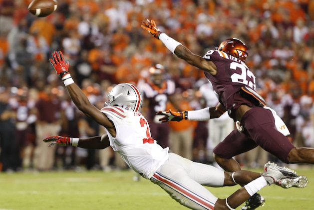 Ohio State wide receiver Michael Thomas, bottom, reaches for the ball as Virginia Tech defensive end Dewayne Alford (22) defends during the second half of an NCAA college football game in Blacksburg, Va., Monday, Sept. 7, 2015. Alford was called for a foul on the play. (AP Photo/Steve Helber)