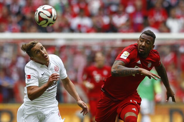 Mainz’s Pablo de Blasis from Argentina, left, and Bayern's Jerome Boateng challenge for the ball during the German first division Bundesliga soccer match between FC Bayern Munich and 1. FSV Mainz 05 at the Allianz Arena in Munich, Germany, on Saturday, May 23, 2015. (AP Photo/Matthias Schrader)
