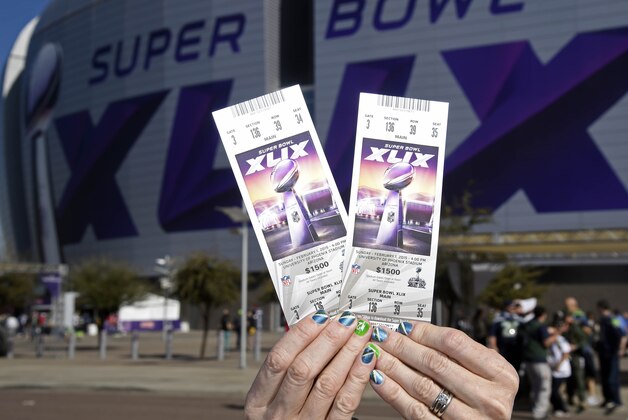 Feb 1, 2015; Glendale, AZ, USA; A fan holds up a pair of tickets before Super Bowl XLIX between the New England Patriots and the Seattle Seahawks at University of Phoenix Stadium. Mandatory Credit: Kirby Lee-USA TODAY Sports