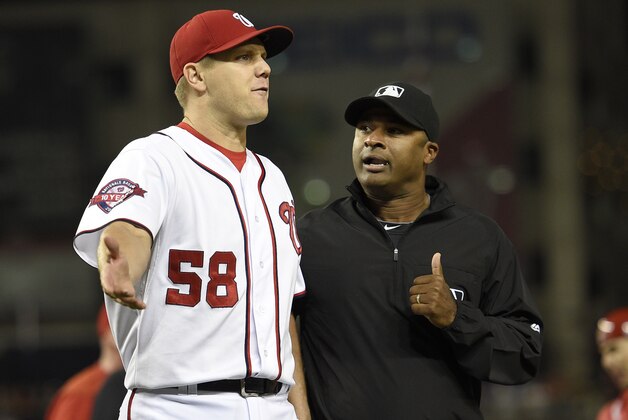 Washington Nationals relief pitcher Jonathan Papelbon (58) reacts next to second base umpire Alan Porter, right, during the ninth inning of an interleague baseball game, Wednesday, Sept. 23, 2015, in Washington. Papelbon was ejected for hitting Baltimore Orioles' Manny Machado with a pitch. The Orioles won 4-3. (AP Photo/Nick Wass)