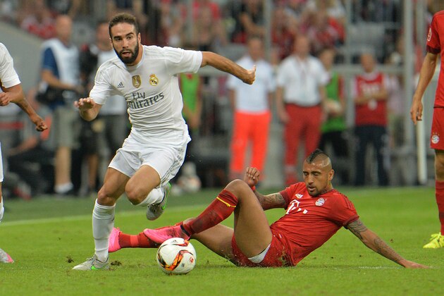 Munichs Douglas Costa, right, fights for the ball with Madrid's Daniel Carvajal during  their friendly soccer match between FC Bayern and Real Madrid in the Allianz Arena stadium in Munich, southern Germany, Wednesday, Aug. 5, 2015. (AP Photo/Kerstin Joensson)