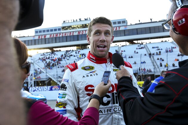 Carl Edwards gives interviews after winning the pole position for Sunday's NASCAR Sprint Cup series auto race at New Hampshire Motor Speedway in Loudon, N.H., Friday, Sept. 25, 2015  (AP Photo/Cheryl Senter)