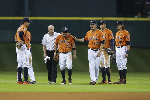 Sep 25, 2015; Houston, TX, USA; Houston Astros second baseman Jose Altuve (27) is escorted off the field after a collision during the seventh inning against the Texas Rangers at Minute Maid Park. Mandatory Credit: Troy Taormina-USA TODAY Sports