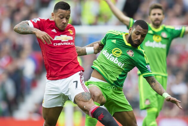 Manchester United's Memphis Depay, left, fights for the ball against Sunderland's Yann M'Vila during the English Premier League soccer match between Manchester United and Sunderland at Old Trafford Stadium, Manchester, England, Saturday, Sept. 26, 2015. (AP Photo/Jon Super)