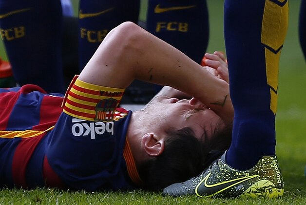 FC Barcelona's Lionel Messi lies on the pitch injured during a Spanish La Liga soccer match against Las Palmas at the Camp Nou stadium in Barcelona, Spain, Saturday, Sept. 26, 2015. (AP Photo/Manu Fernandez)