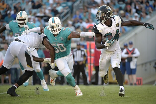 Jacksonville Jaguars running back T.J. Yeldon (24) rushes for yardage past Miami Dolphins defensive end Olivier Vernon (50) during the second half of an NFL football game in Jacksonville, Fla., Sunday, Sept. 20, 2015. The Jaguars won 23-20.(AP Photo/Phelan M. Ebenhack)