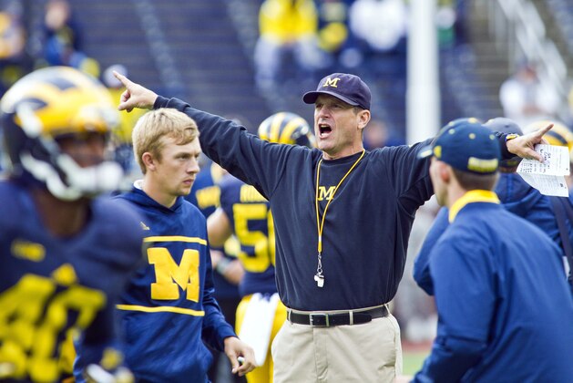 Michigan head coach Jim Harbaugh directs his players during warmups before an NCAA college football game against UNLV in Ann Arbor, Mich., Saturday, Sept. 19, 2015. (AP Photo/Tony Ding)