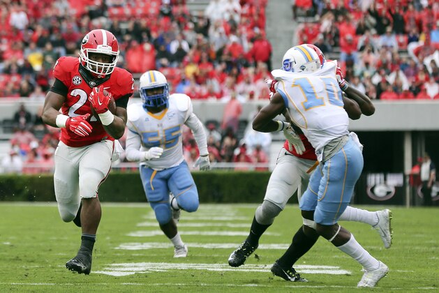 Georgia running back Nick Chubb (27) runs away from Southern's Kentavious Preston (55) and  Danny Johnson (10) for a touchdown in the first half of an NCAA college football game  Saturday, Sept. 26, 2015, in Athens , Ga. (AP Photo/John Bazemore)