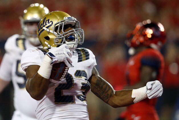 UCLA running back Nate Starks (23) celebrates after scoring a touchdown against Arizona during the first half of an NCAA college football game, Saturday, Sept. 26, 2015, in Tucson, Ariz. (AP Photo/Rick Scuteri)