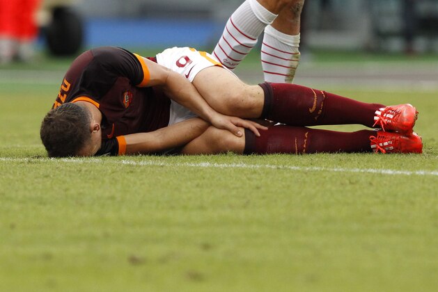 Roma’s Edin Dzeko lies on the pitch after injuring during a Serie A soccer match between Roma and Carpi, at Rome's Olympic stadium, Saturday, Sept. 26, 2015. (AP Photo/Riccardo De Luca)