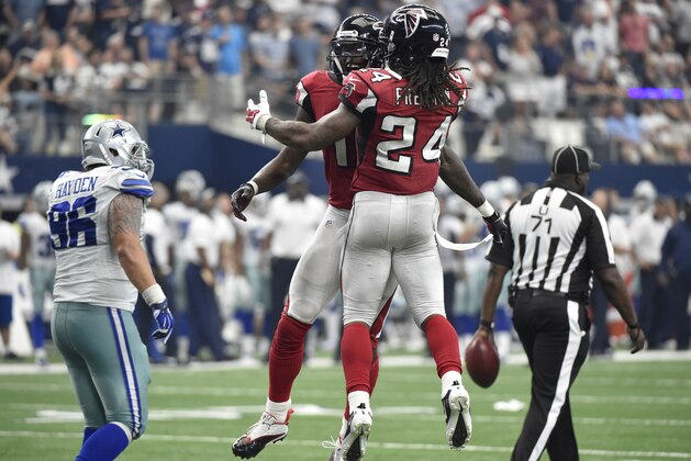 Dallas Cowboys' Nick Hayden (96) walks to the sideline as Atlanta Falcons' Julio Jones, rear, and Devonta Freeman (24) celebrate a touchdown by Jones during the second half of an NFL football game Sunday, Sept. 27, 2015, in Arlington, Texas. Umpire Ruben Fowler (71) walks the ball back downfield. (AP Photo/Michael Ainsworth )