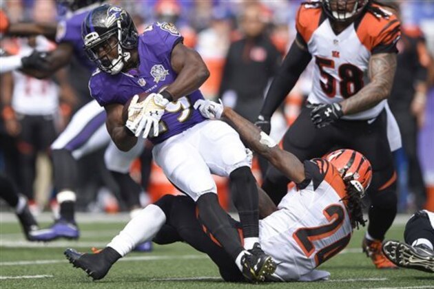 Baltimore Ravens running back Justin Forsett (29) is stopped by Cincinnati Bengals cornerback Adam Jones (24) during the first half of an NFL football game in Baltimore, Sunday, Sept. 27, 2015. (AP Photo/Nick Wass)