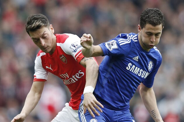 Arsenal's German midfielder Mesut Ozil (L) vies with Chelsea's Belgian midfielder Eden Hazard during the English Premier League football match between Arsenal and Chelsea at the Emirates Stadium in London on April 26, 2015.
AFP PHOTO / ADRIAN DENNIS

RESTRICTED TO EDITORIAL USE. No use with unauthorized audio, video, data, fixture lists, club/league logos or live services. Online in-match use limited to 45 images, no video emulation. No use in betting, games or single club/league/player publications.        (Photo credit should read ADRIAN DENNIS/AFP/Getty Images)