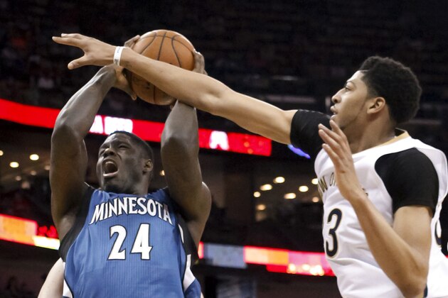 New Orleans Pelicans forward Anthony Davis (23) fouls Minnesota Timberwolves forward Anthony Bennett (24) during the first half of an NBA basketball game in New Orleans, Sunday, March 29, 2015. (AP Photo/Scott Threlkeld)