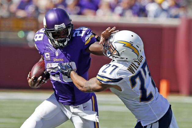 El running back Adrian Peterson (28), de los Vikings de Minnesota, se libra del strong safety Jimmy Wilson (27), de los Chargers de San Diego, para enfilarse a un touchdown en la segunda mitad del partido en Minneapolis, el doming 27 de septiembre de 2015. (AP Photo/Jim Mone)
