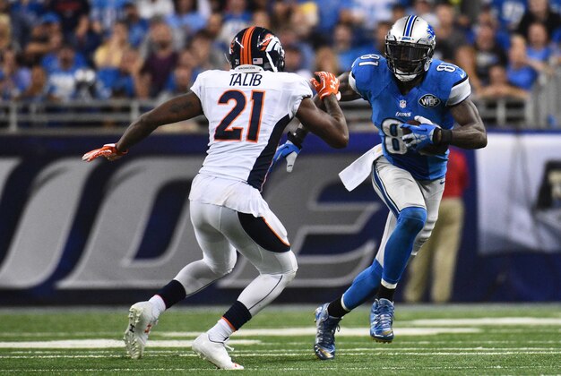 Sep 27, 2015; Detroit, MI, USA; Detroit Lions wide receiver Calvin Johnson (81) carries the ball as Denver Broncos cornerback Aqib Talib (21) defends during the fourth quarter at Ford Field. Mandatory Credit: Tim Fuller-USA TODAY Sports
