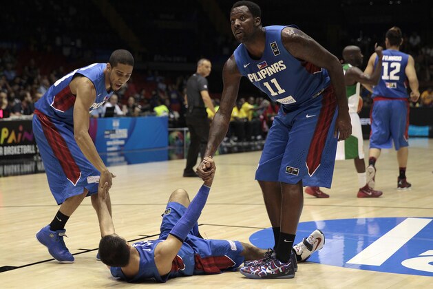 Philippines players Andray Blatche, right, and Gabe Norwood, left, help teammate Lewis Tenorio during the Group B Basketball World Cup match against Senegal in Seville, Spain, Thursday, Sept. 4, 2014. The 2014 Basketball World Cup competition will take place in various cities in Spain from Aug. 30 through to Sept. 14. (AP Photo/Miguel Angel Morenatti)