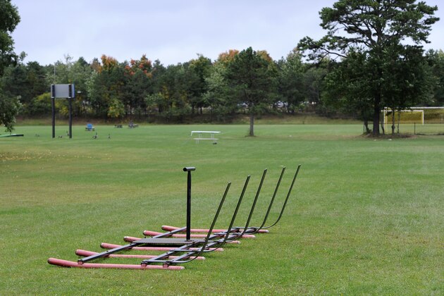 Equipment sits on a football practice field near the main entrance for Shoreham-Wading River High School, Thursday, Oct. 2, 2014, in Shoreham, N.Y. Authorities say Tom Cutinella, 16-year-old football player at the high school, died at a hospital the night before after suffering a head injury in an on-field collision during a game with John Glenn High School in Elwood, N.Y.  (AP Photo/Kathy Kmonicek)