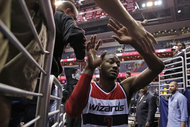 Washington Wizards guard John Wall (2) greets fans after an NBA basketball game against the Portland Trail Blazers, Monday, March 16, 2015, in Washington. The Wizards won 105-97. (AP Photo/Alex Brandon)