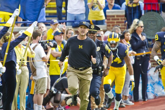 Michigan head coach Jim Harbaugh leads his players out of the Michigan Stadium tunnel to run on the field before an NCAA college football game against BYU in Ann Arbor, Mich., Saturday, Sept. 26, 2015. (AP Photo/Tony Ding)