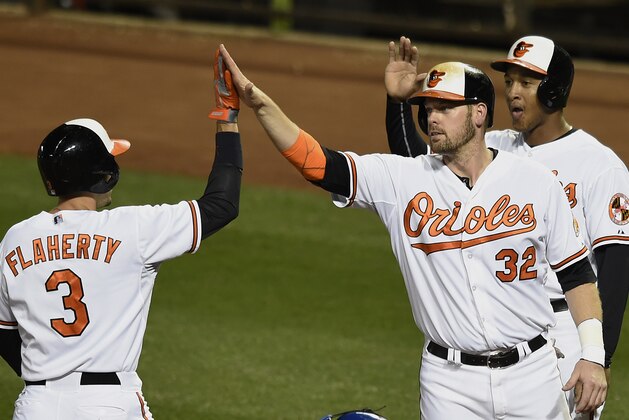 Baltimore Orioles' Ryan Flaherty, left, is congratulated by Matt Wieters, center, and Jonathan Schoop, who both scored on his thre- run home run against the Toronto Blue Jays in the second inning of a baseball game, Monday, Sept. 28, 2015, in Baltimore. (AP Photo/Gail Burton)