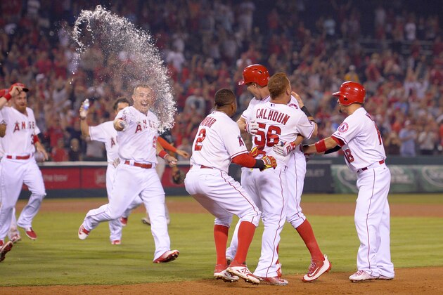 Los Angeles Angels' David Murphy, third from right, is mobbed by teammates after hitting a walk-off single to win in the ninth inning of a baseball game against the Oakland Athletics, Monday, Sept. 28, 2015, in Anaheim, Calif. (AP Photo/Mark J. Terrill)