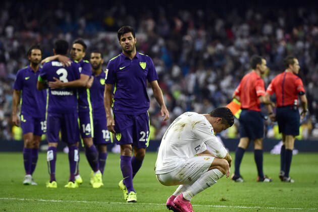 Real Madrid's Portuguese forward Cristiano Ronaldo crouches down (R) at the end of the Spanish league football match Real Madrid CF vs Malaga CF at the Santiago Bernabeu stadium in Madrid on September 26, 2015.    AFP PHOTO / PIERRE-PHILIPPE MARCOU        (Photo credit should read PIERRE-PHILIPPE MARCOU/AFP/Getty Images)