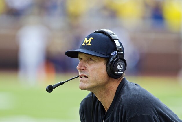 Michigan head coach Jim Harbaugh, wearing a headset, on the sideline in the first quarter of an NCAA college football game against BYU in Ann Arbor, Mich., Saturday, Sept. 26, 2015. (AP Photo/Tony Ding)