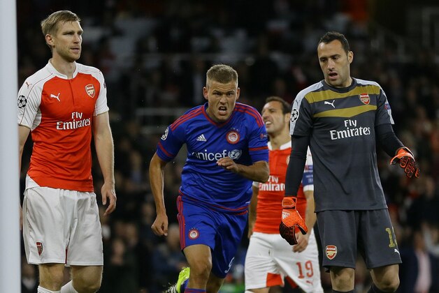 Olympiakos' Alfred Finnbogason, centre, celebrates after scoring his side's third goal during the Champions League Group F soccer match between Arsenal and Olympiakos at Emirates stadium in London Tuesday, Sept. 29, 2015. (AP Photo/Kirsty Wigglesworth)