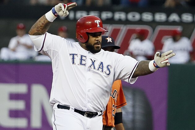 Texas Rangers' Prince Fielder gestures to the dugout after reaching second, following a single that scored Delino DeShields during the first inning of a baseball game against the Houston Astros on Tuesday, Sept. 15, 2015, in Arlington, Texas. Astros second baseman Jose Altuve is at rear. (AP Photo/Tony Gutierrez)