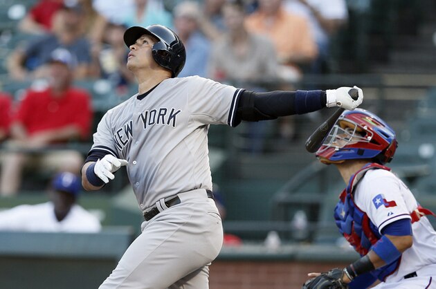 New York Yankees' Alex Rodriguez follows through on a swing as Texas Rangers' Robinson Chirinos watches in the first inning of a baseball game Wednesday, July 29, 2015, in Arlington, Texas. (AP Photo/Tony Gutierrez)