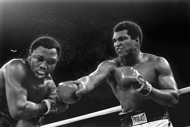 FILE - In this Oct. 1, 1975 file photo, spray flies from the head of challenger Joe Frazier, left, as heavyweight champion Muhammad Ali connects with a right in the ninth round of their title fight in Manila, Philippines.(AP Photo/Mitsunori Chigita, File)
