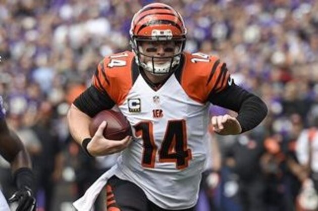 Cincinnati Bengals quarterback Andy Dalton (14) breaks a tackle by Baltimore Ravens inside linebacker C.J. Mosley (57) as he runs for a touchdown during the first half of an NFL football game in Baltimore, Sunday, Sept. 27, 2015. (AP Photo/Nick Wass)