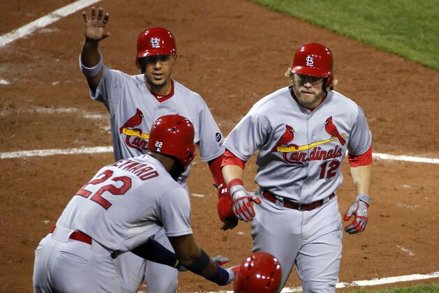 St. Louis Cardinals' Mark Reynolds (12) celebrates with teammates Jon Jay, left rear, and Jason Heyward (22) after hitting a  pinch hit two-run home run off Pittsburgh Pirates relief pitcher Mark Melancon in the ninth inning of a baseball game in Pittsburgh, Monday, Sept. 28, 2015. (AP Photo/Gene J. Puskar)