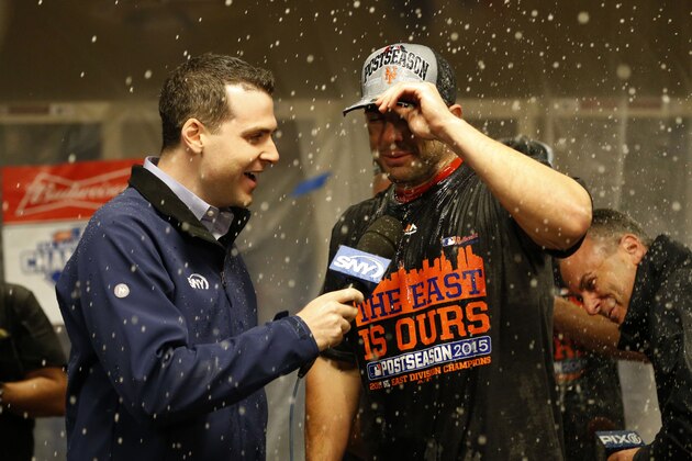 New York Mets' David Wright is interviewed in the clubhouse as they celebrate in the clubhouse after the clinching the NL East title following their 10-2 win over the Cincinnati Reds in a baseball game, Saturday, Sept. 26, 2015, in Cincinnati. (AP Photo/Aaron Doster)