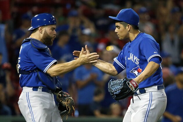 Toronto Blue Jays' Roberto Osuna, right, and Russell Martin celebrate after the Blue Jays defeated the Boston Red Sox 5-1 in 10 innings during a baseball game in Boston, Tuesday, Sept. 8, 2015. (AP Photo/Michael Dwyer)